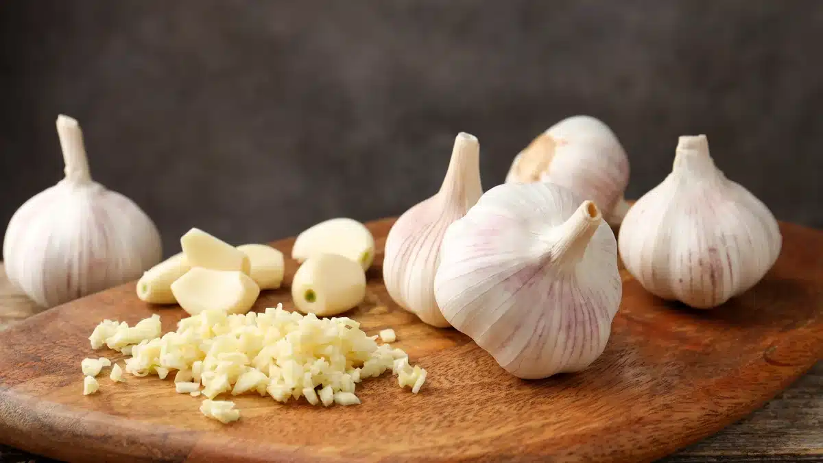 Ajo picado y bulbos en la mesa de madera, en primer plano