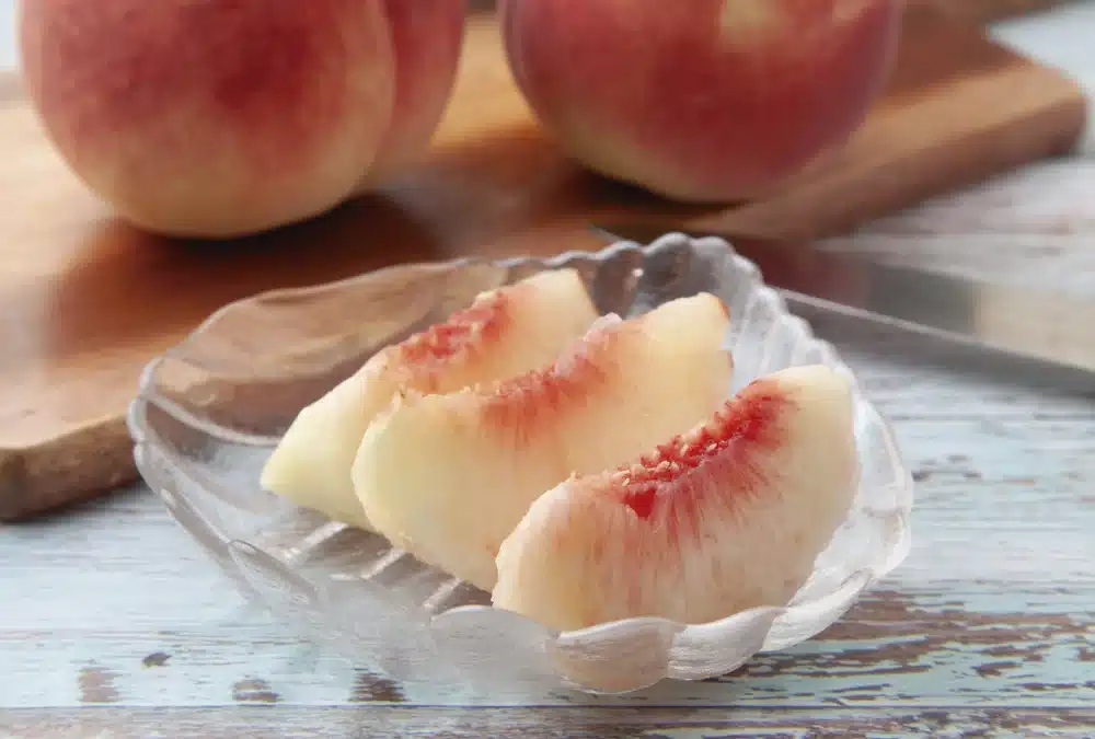 Bol con piezas de melocotón blanco rico en agua